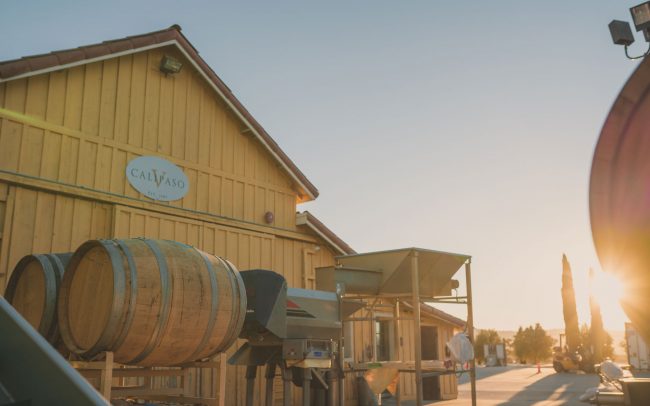 CaliPaso winery crush pad with barrels on racks and equipment