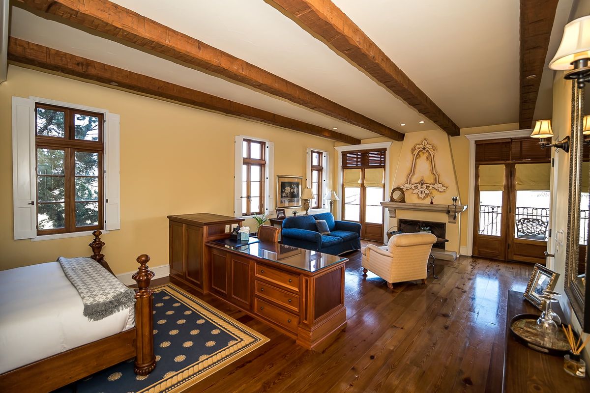 Pinot-Gringio-1-of-10_9f3e1f2132c9304b3d1c1034033d63bb Room with rafters on the ceiling and a decorative fireplace with blue couch and chair in front